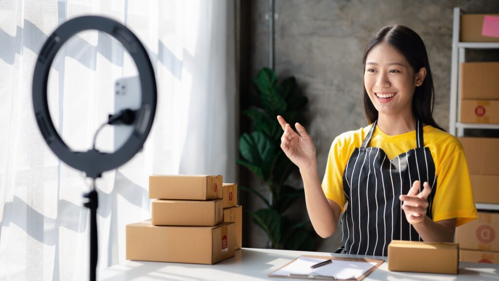 Female online store owner doing live selling on social media, chatting with customers, selling produ