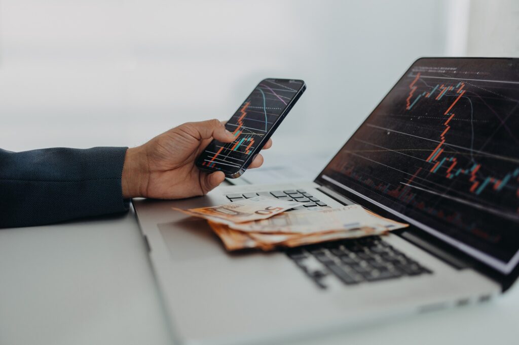 Businessman man counting euro money working on computer and smartphone at office desk, inflation