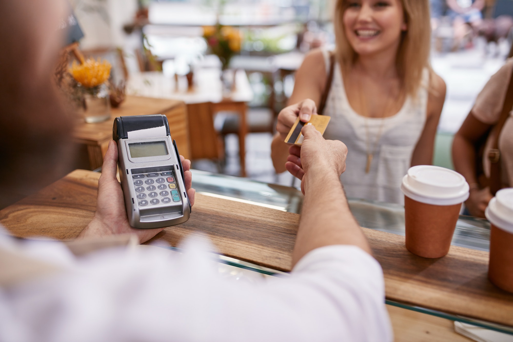 customer paying at a cafe with credit card - Merchant Cash Advance (MCA)