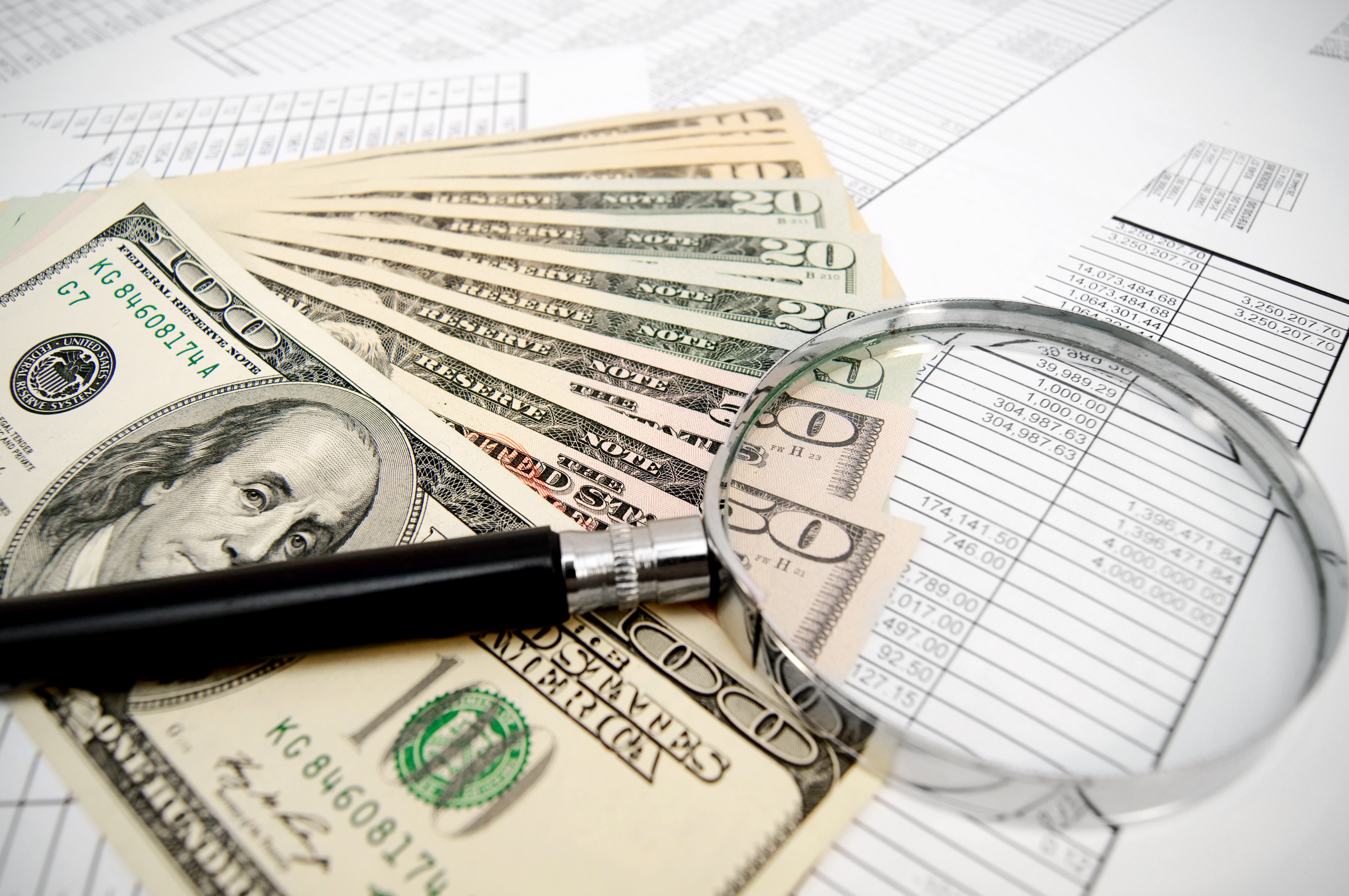magnifier and dollars on documents  - Liquor Store Business Loans