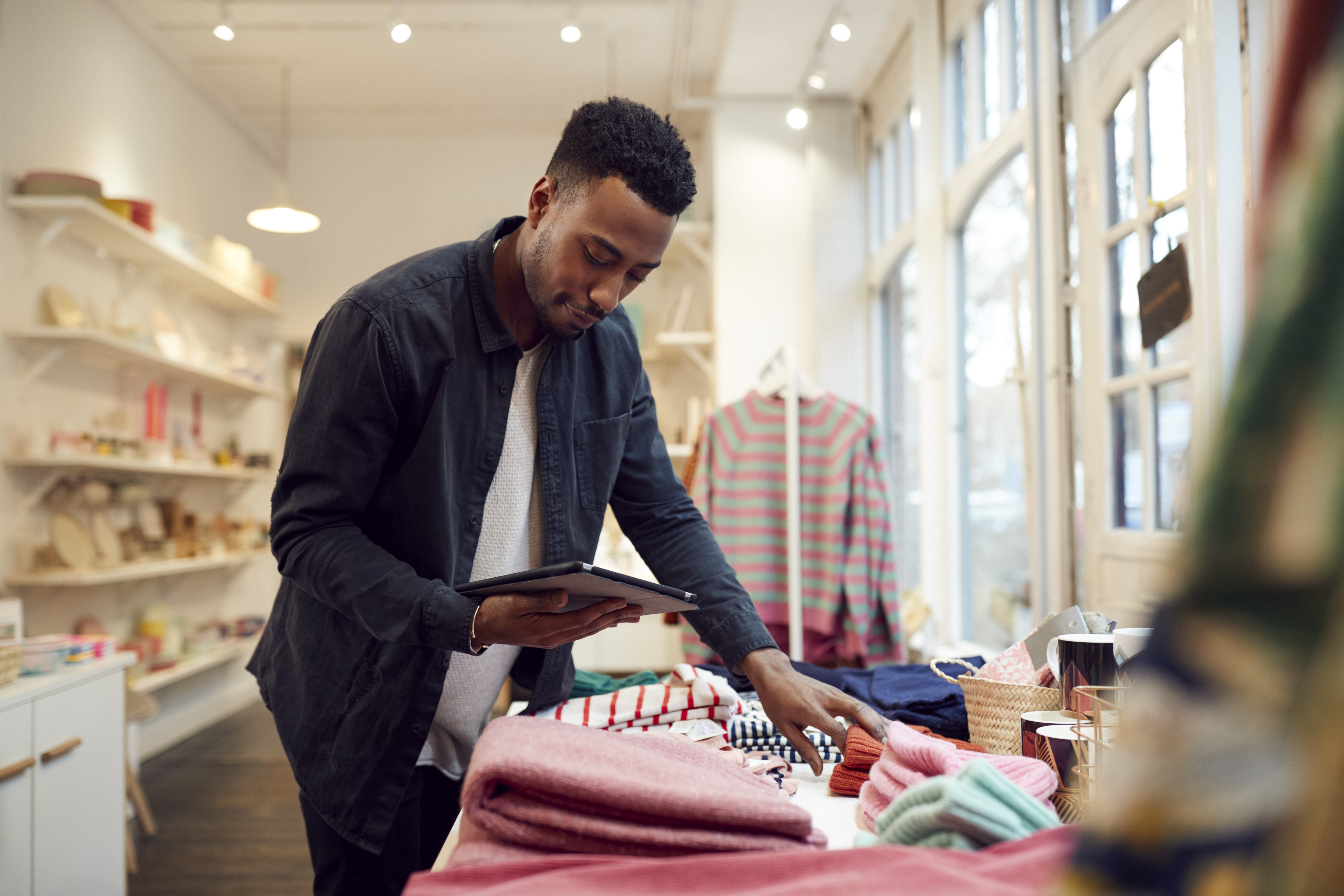 male small business owner checks stock in shop using digital tablet - Blog