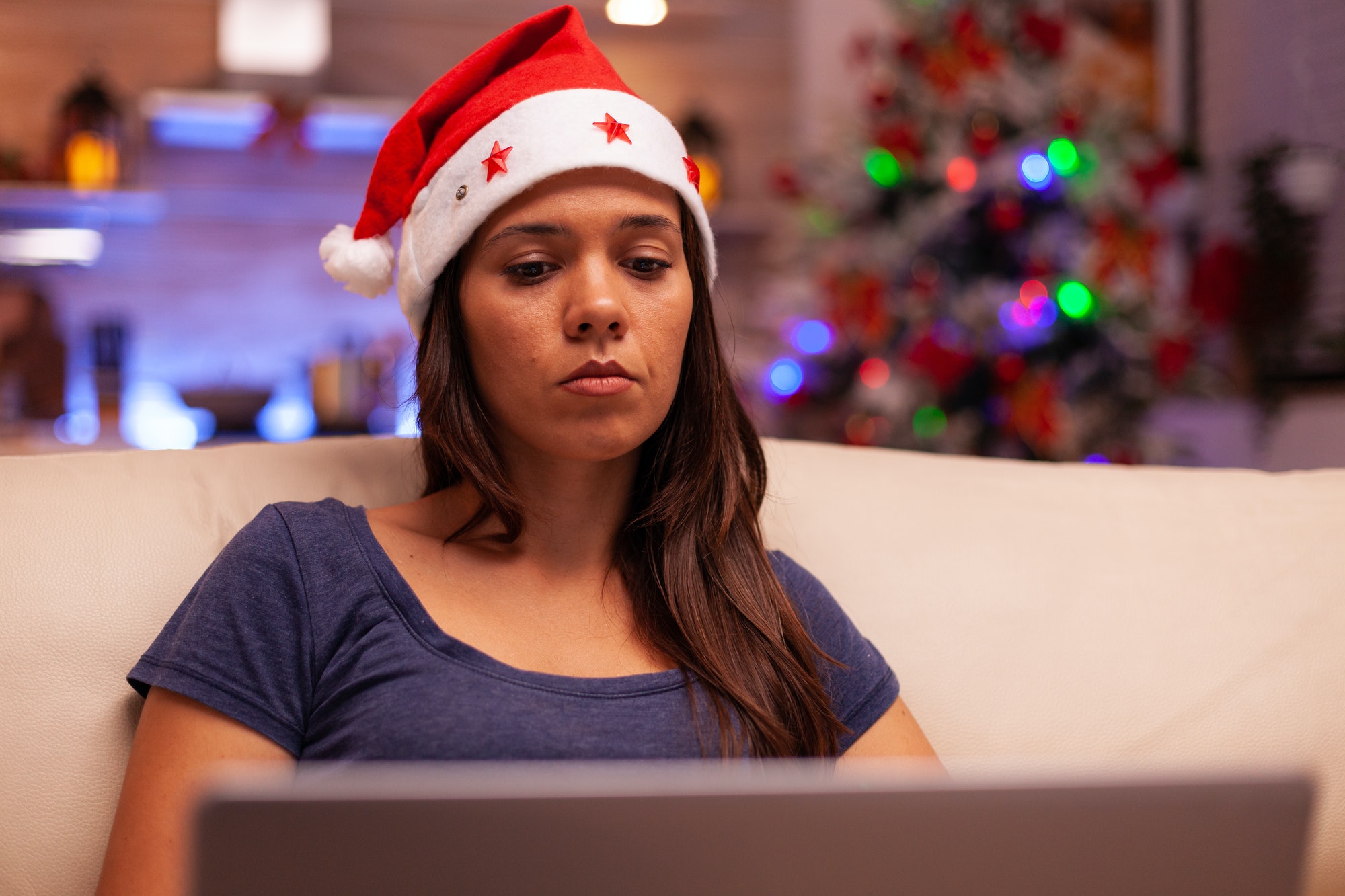 Woman looking at laptop screen reading business email during christmas holiday