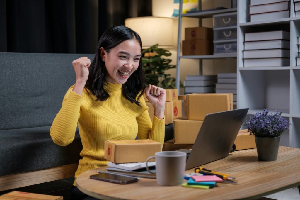 A young Asian small business owner is happy to be able to increase sales for the store.