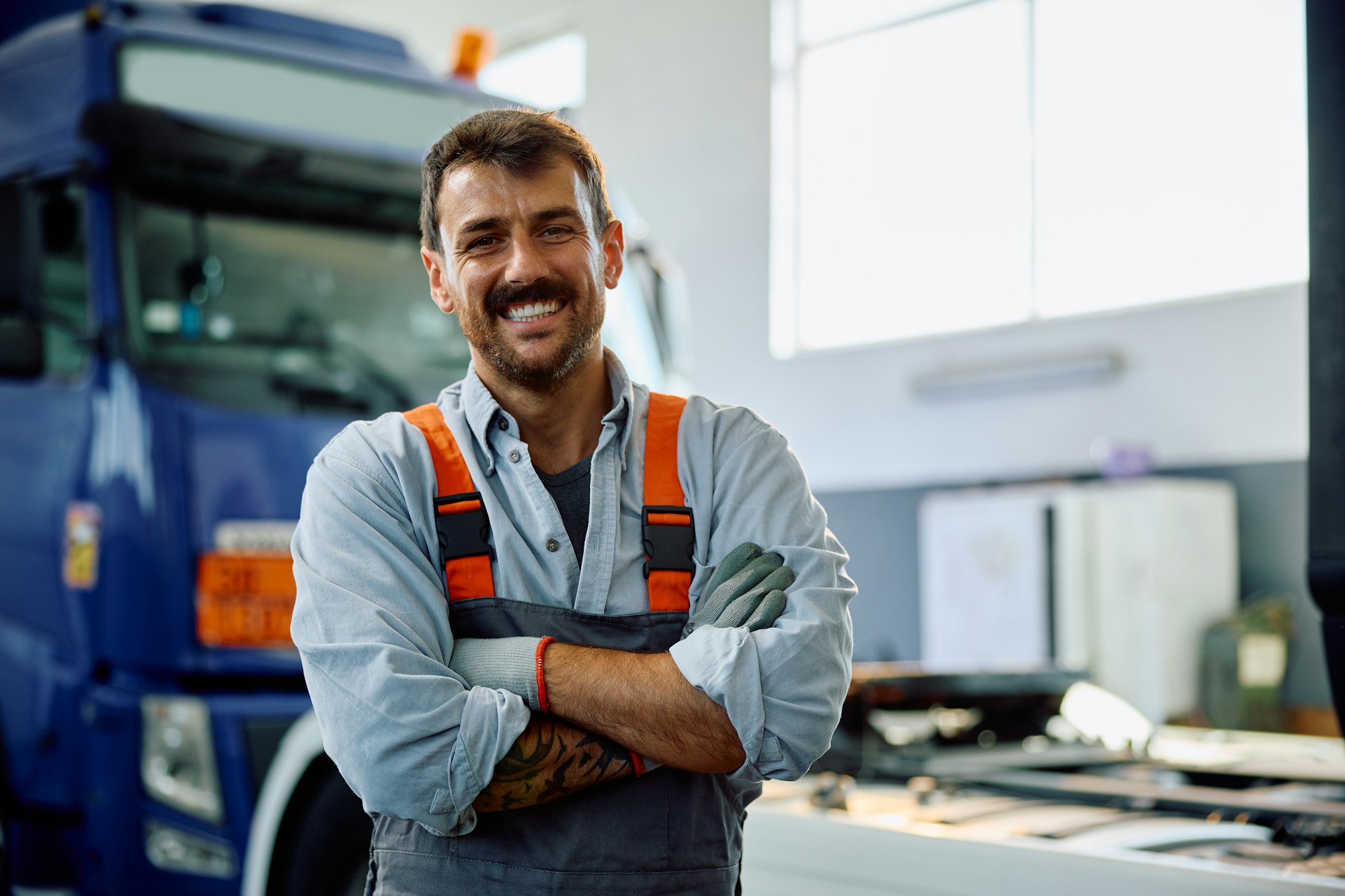 portrait of confident truck repair shop owner looking at camera  - Trucking Business Loans