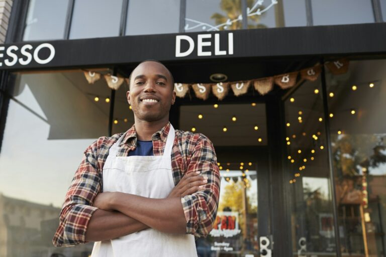 Black male business owner standing outside coffee shop